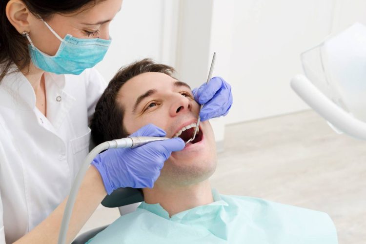 man getting teeth checked at dentist