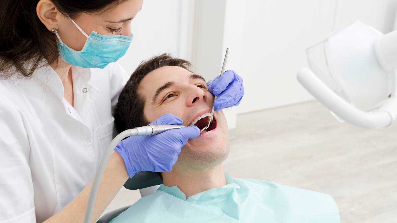 man getting teeth checked at dentist