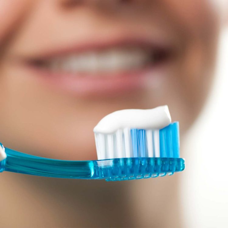 woman with toothpaste on toothbrush ready to clean teeth