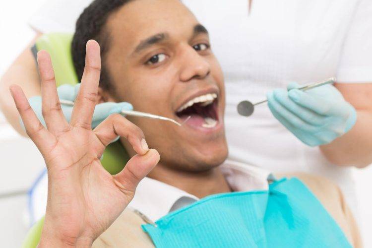 man happily getting his teeth cleaned at dentist