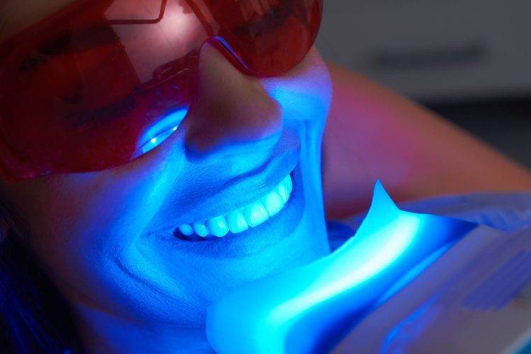 woman smiling while getting her teeth whitened